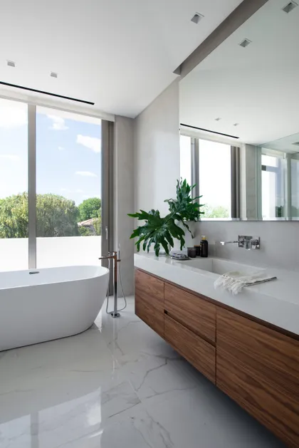 Baño moderno con bañera exenta y ventana grande al exterior — proyecto Casa AA, por Estudio Junor, en Pilar